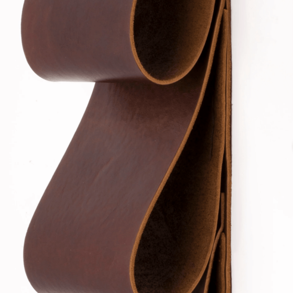 Leather wall art doubles as a 4 bottle hanging wine holder but can also be used for mail, magazines, and towels. Hand cut from premium leather then hand stitched.